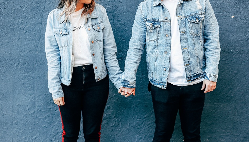Парень и девушка в джинсовых куртках держатся за руки